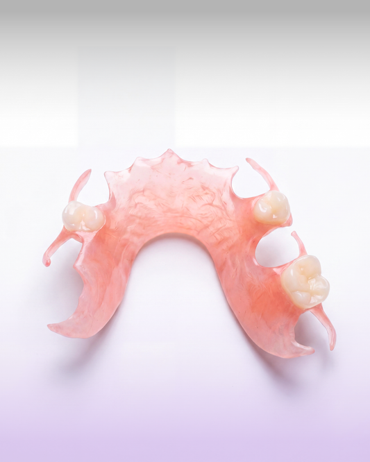 A pink dental appliance or mouthpiece with molded teeth details, photographed on a clean white-to-lavender gradient background.
