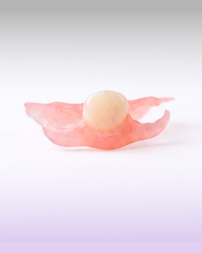 A flexible flipper partial denture for a missing upper tooth, presented on a purple gradient background