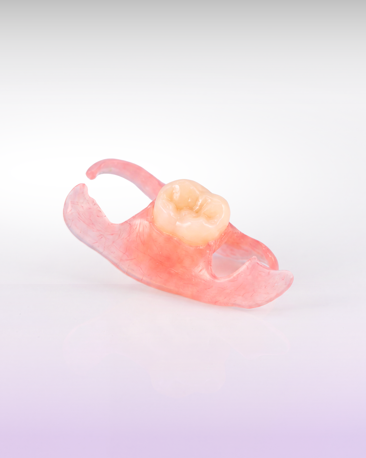 A flexible flipper partial denture for a missing lower back tooth, presented on a purple gradient background
