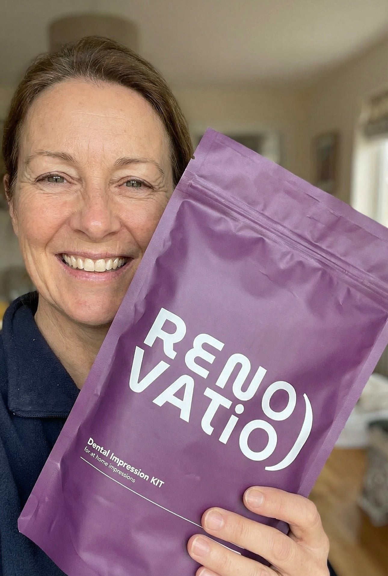 Person holding a purple 'Renovatio Labs' package in an indoor setting